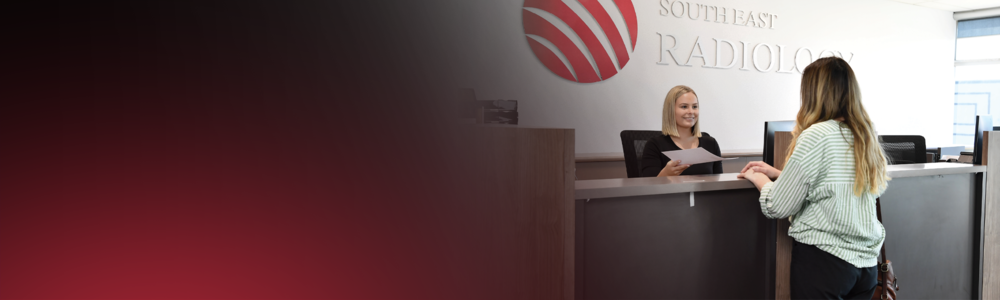 A female patient talks to a receptionist at a South East Radiology clinic.